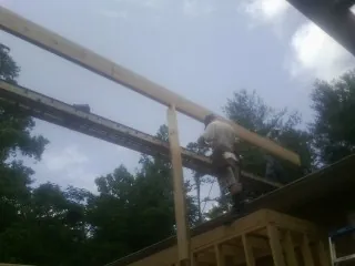 Carpenter setting a ridge beam over a new addition frame — Ice Dam Removal by Roofing Brothers in Ekron