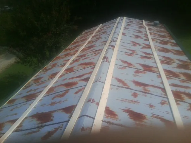 Rusted metal roof panels with new wood purlins before replacement — Storm Damage Roof Repair in Ekron by Roofing Brothers